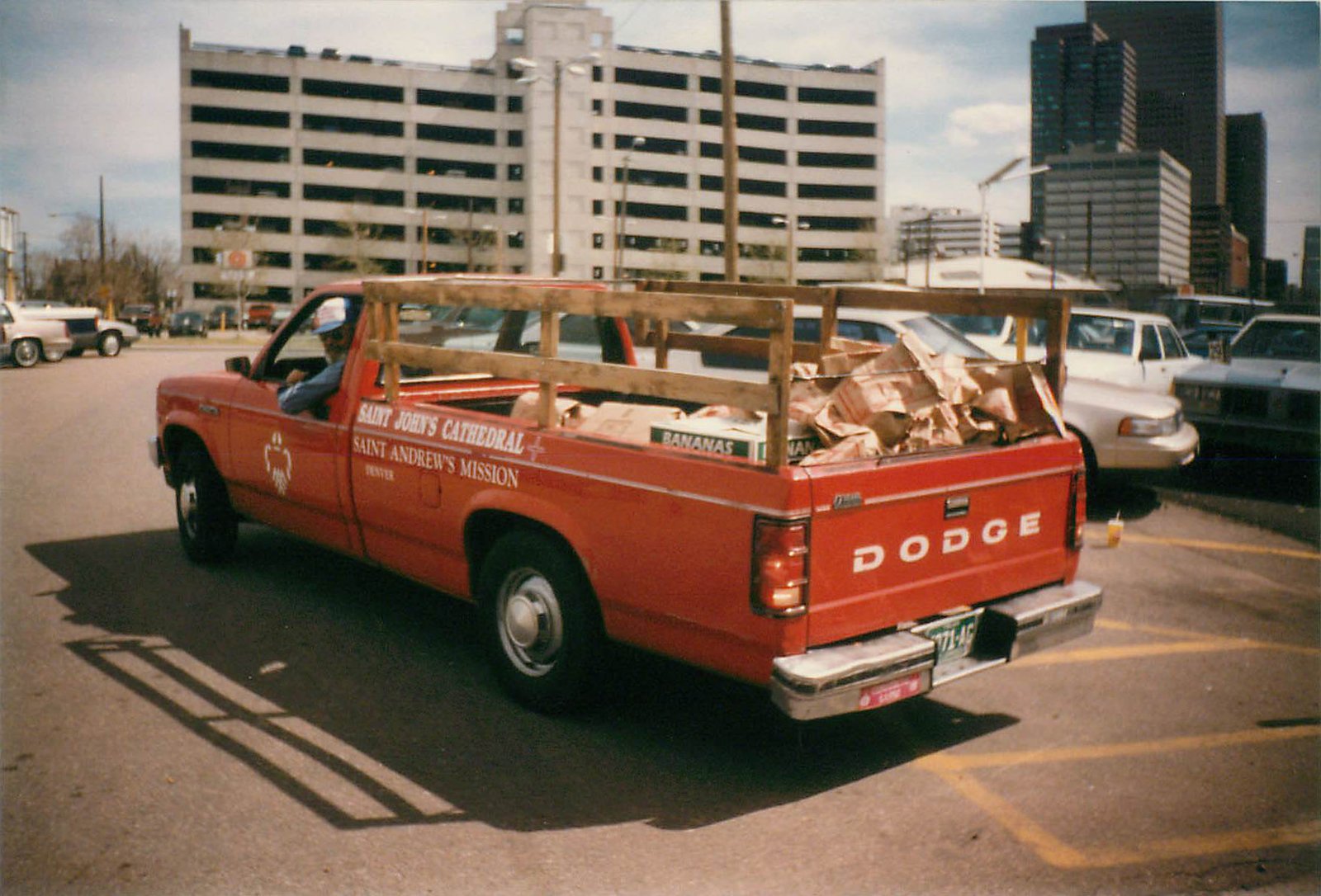 Red pick up truck with the bed filled with boxes.