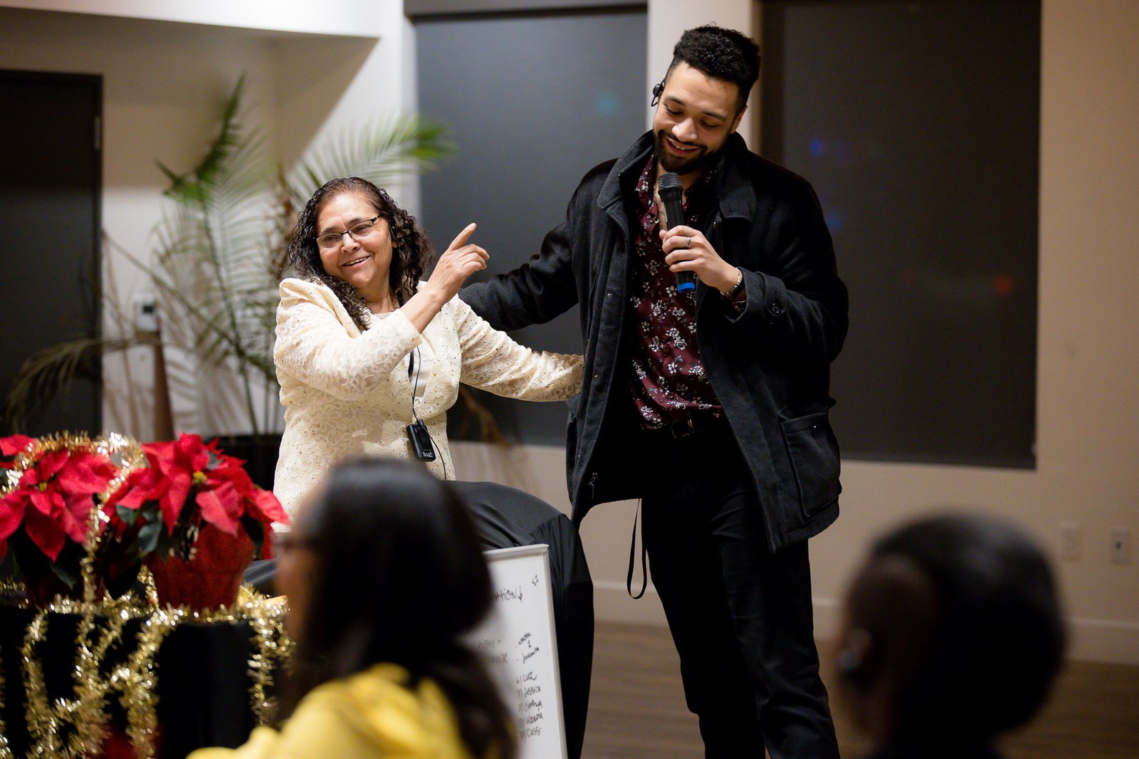 Luz, a storyteller, laughs with Daniel, a Metro Caring volunteer and intern, at the Voices at the Table celebration night. 