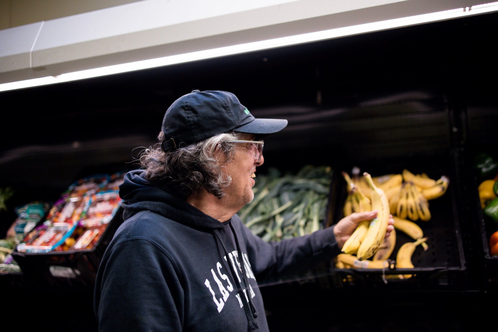A community member picking a banana in Metro Caring's fresh market.