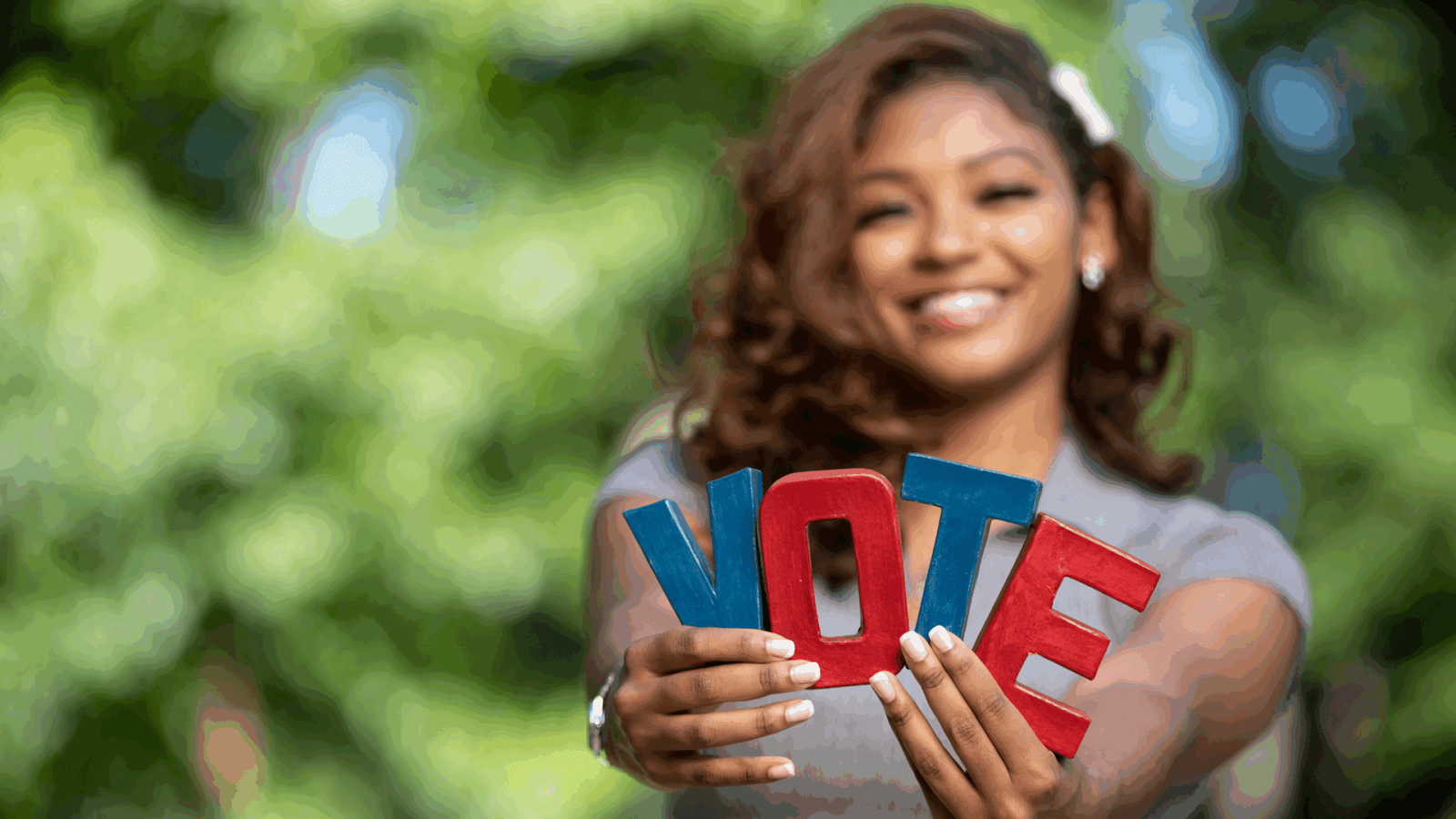 Black woman holding a VOTE sign