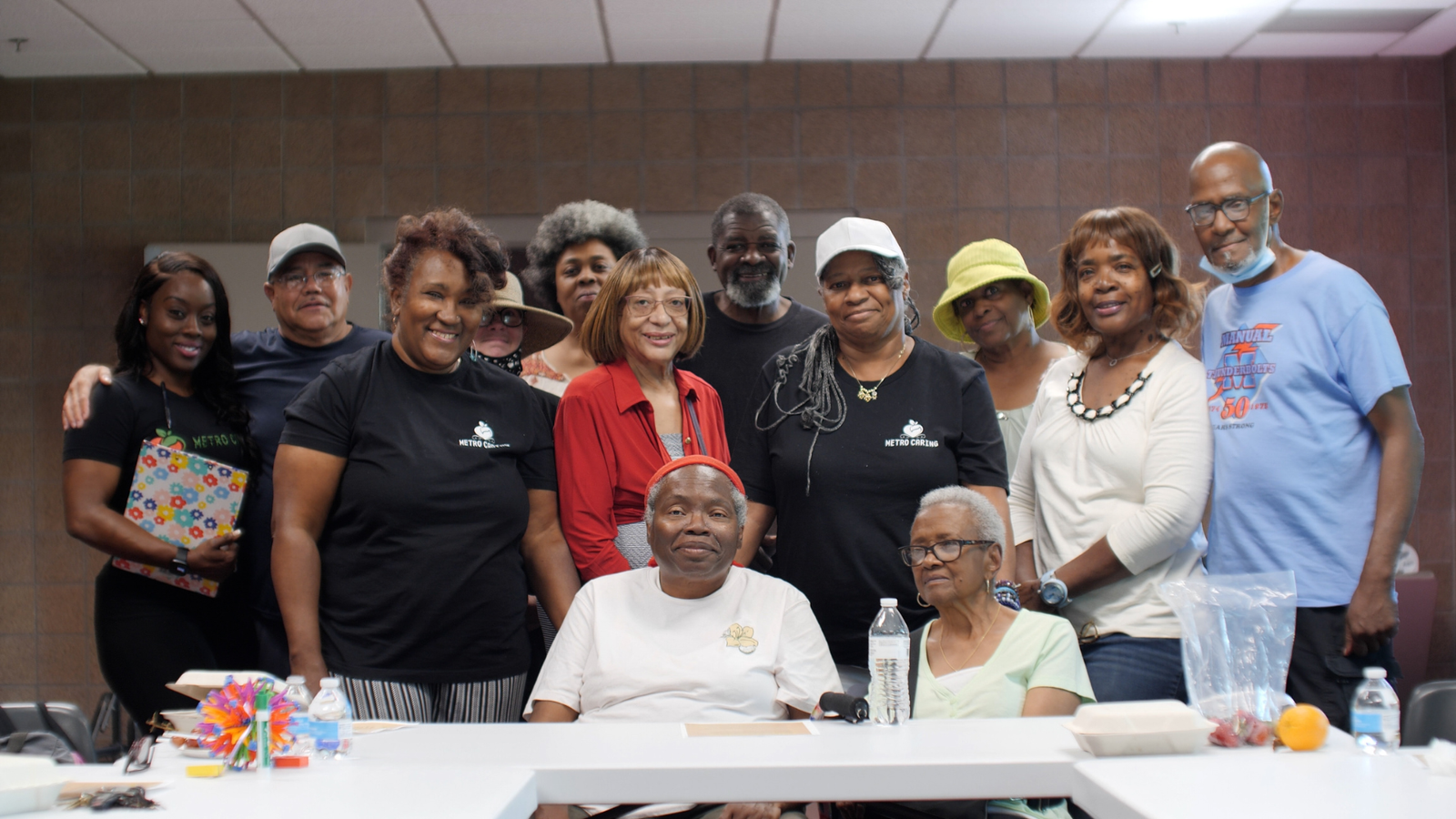 Black folks huddle around a table smiling at the camera at the Hiawatha Davis Recreation Center for Metro Caring's Diabetes Among Friends program.